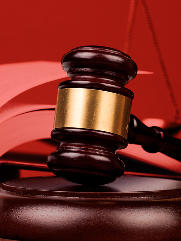 Photograph of a gavel with a red background